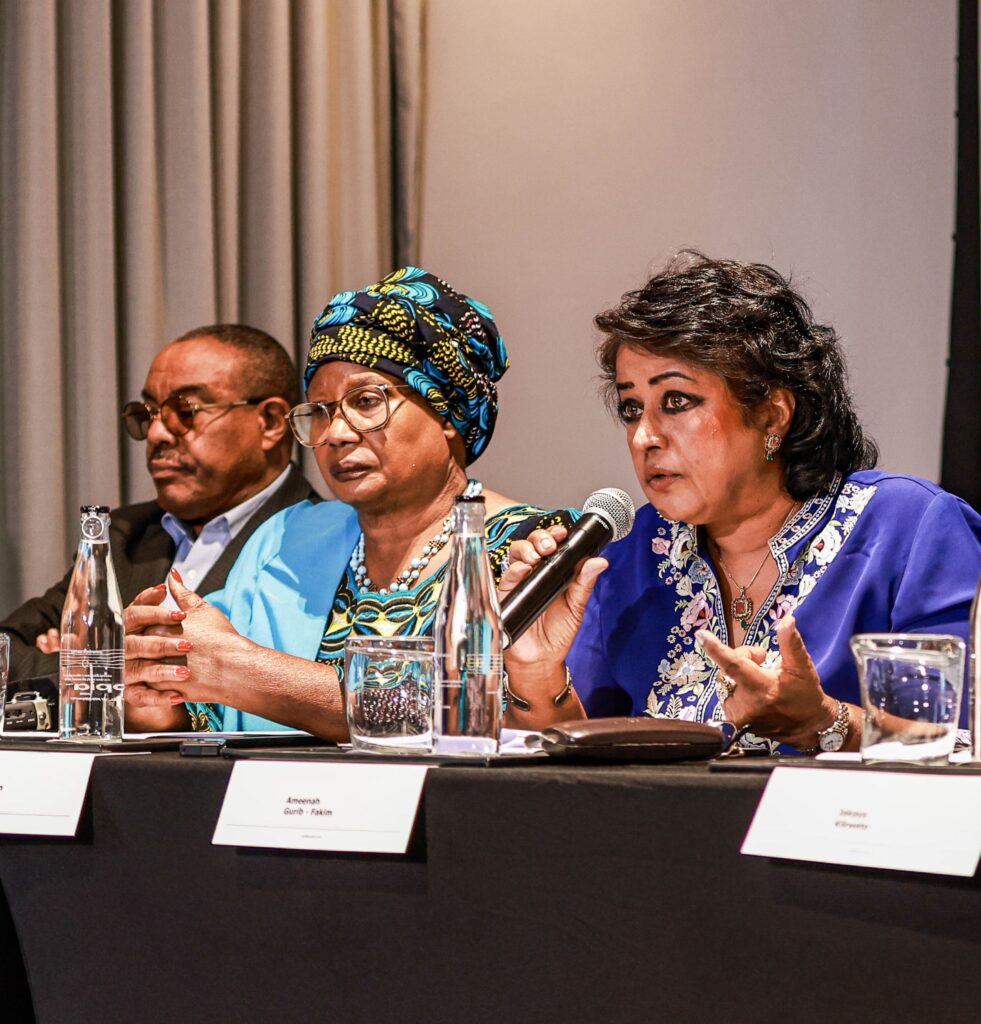 Ameenah Gurib-Fakim speaks on a panel, holding a microphone in her hands